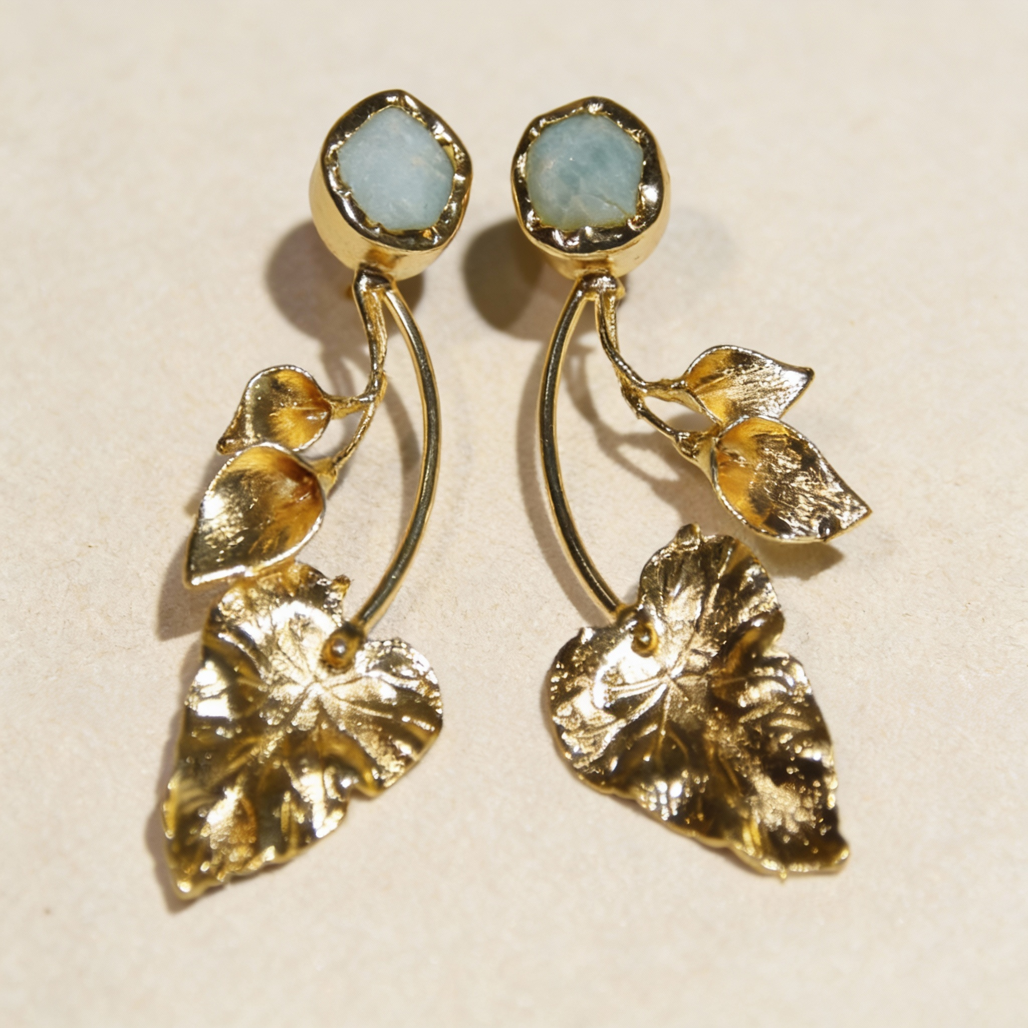 Gold toned textured leaf drop earrings